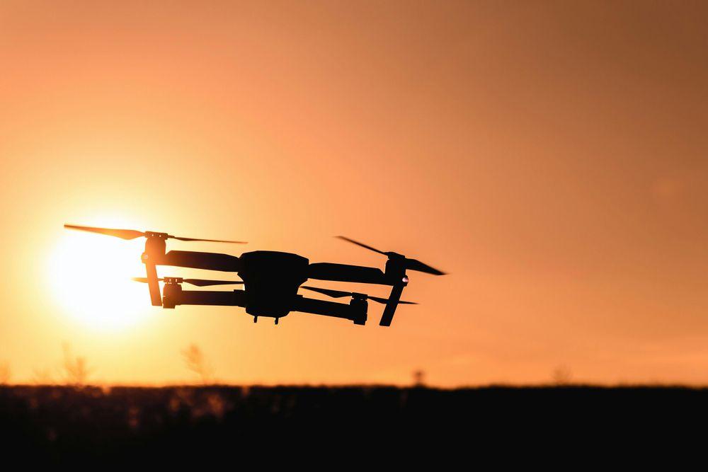 A drone is silouhetted against the setting sun