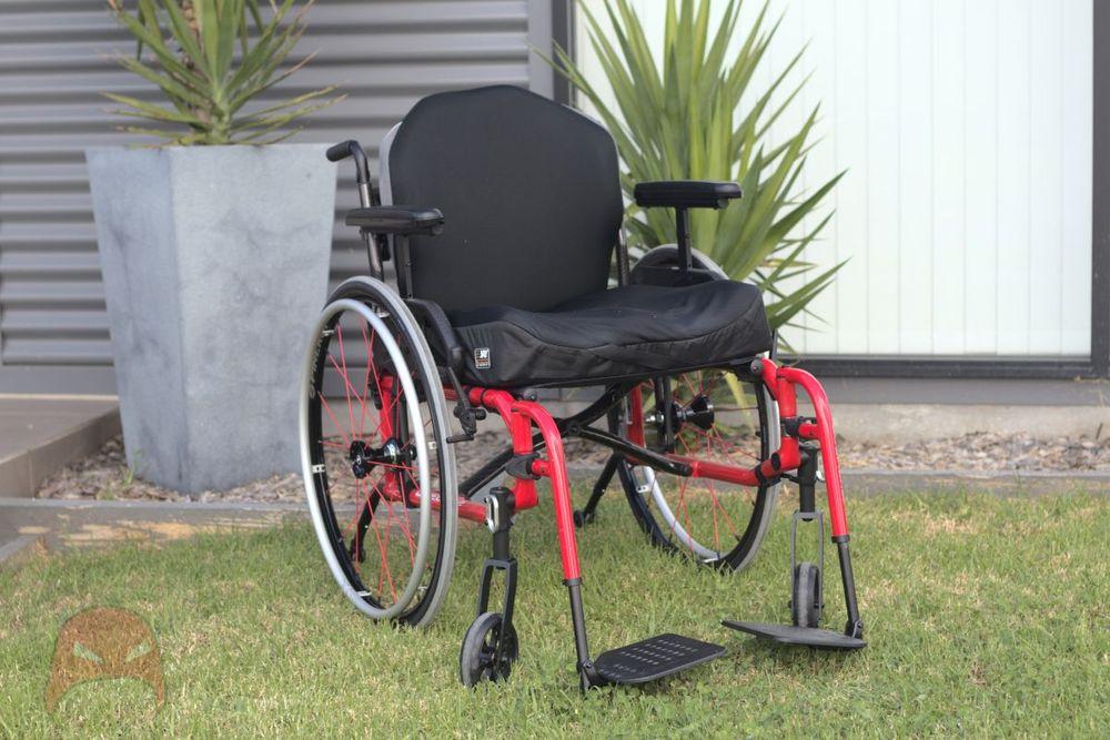 A manual wheelchair sitting on grass